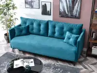 Sofa rozkładana MOLLY TURKUSOWA z pikowanego weluru - w aranżacji ze stolikiem AMIN XL i regałem OTTO A